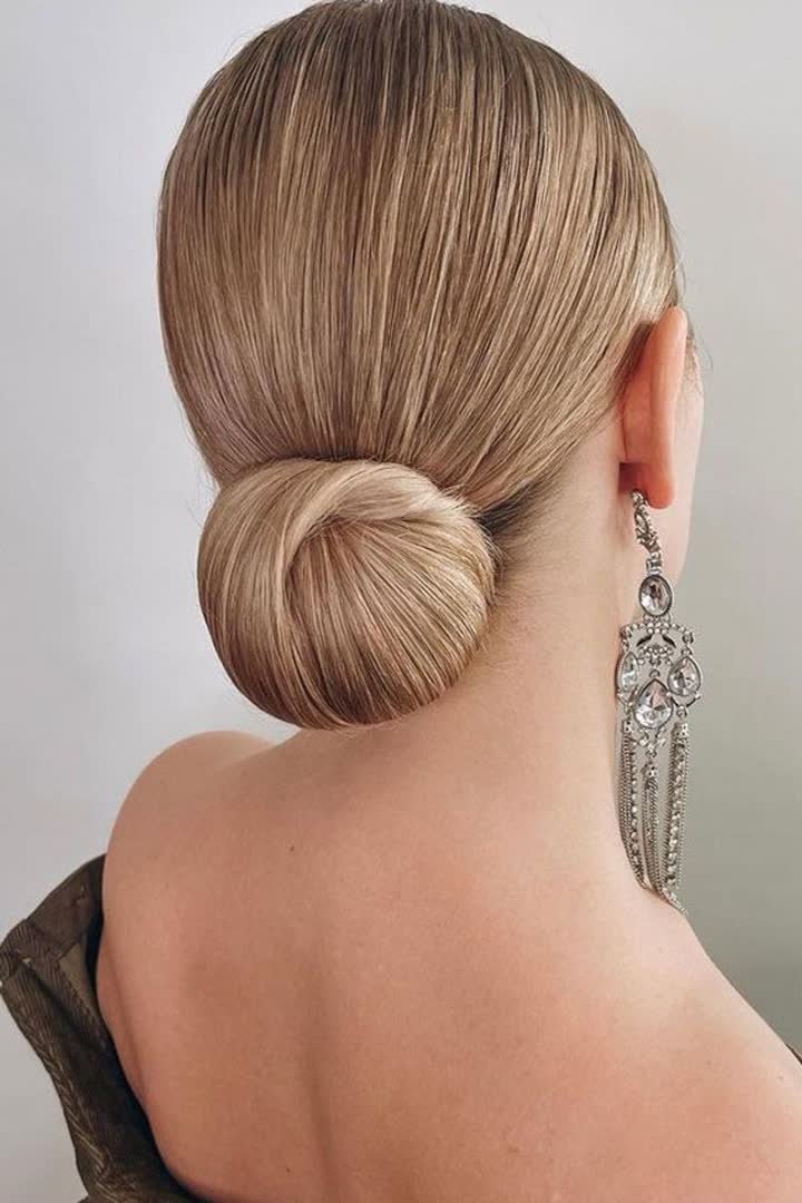 Sleek low knot bun hairstyle for a winter formal