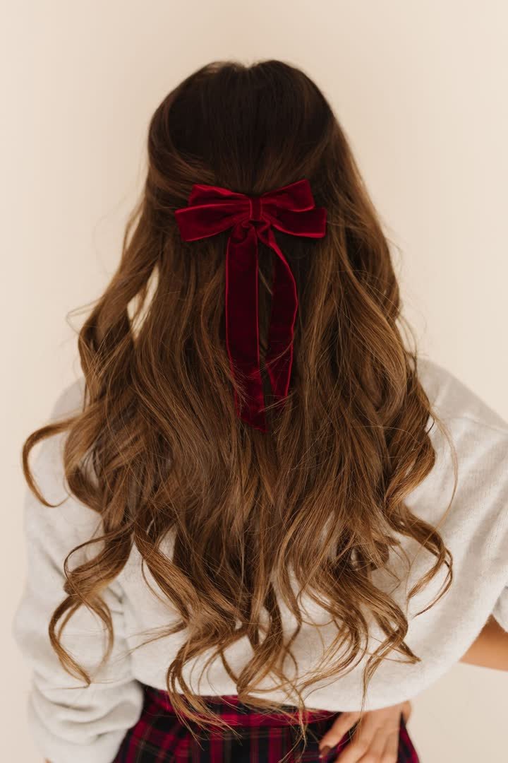 Loose curls with a velvet bow accessory for a winter formal