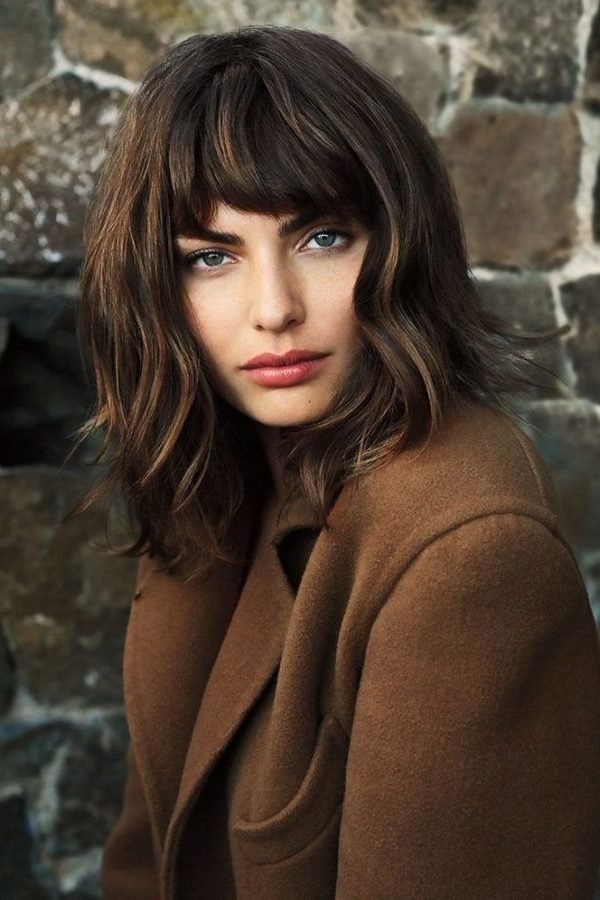 Shaggy bob with wispy curtain bangs and a winter coat
